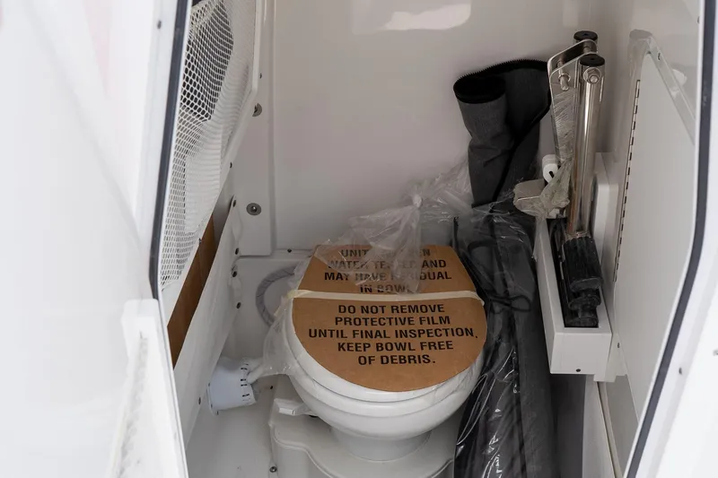 Slide: The Image of Interior of 2026 Sea Hunt Ultra 265 SE boat with covered toilet and storage items. - 36