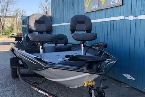 Slide: The Image of 2026 Tracker Pro Team 175 Crappie Edition boat, parked near a blue building. - 4