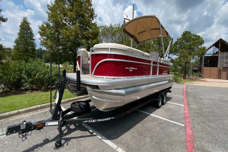 Slide: The Image of 2025 Sun Tracker Party Barge 24 DLX pontoon boat on trailer in parking lot. - 7