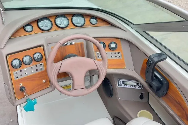 Slide: The Image of Dashboard of a 2000 Cobalt 252 boat with wood accents and steering wheel. - 14