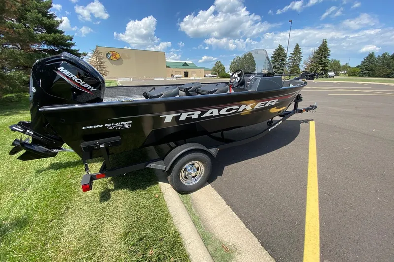 Slide: The Image of 2026 Tracker Pro Guide V-16 SC boat on trailer, parked outdoors under blue sky. - 7