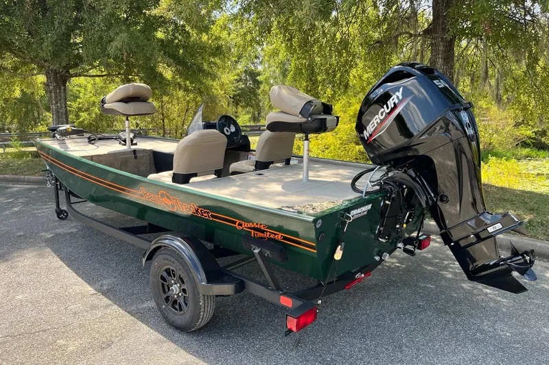 Slide: The Image of 2026 Tracker Bass Tracker Classic Limited boat with Mercury engine in a scenic outdoor setting. - 3