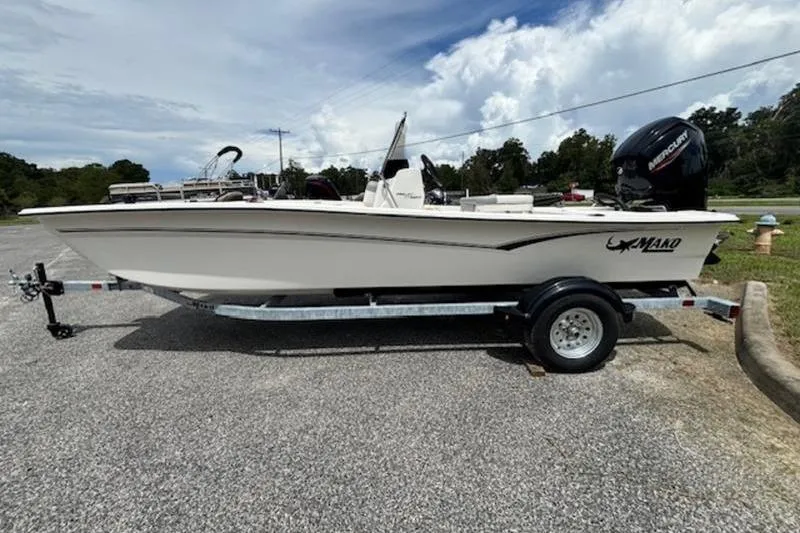 The Image of 2026 Mako Pro Skiff 17 CC boat on trailer, parked outdoors under cloudy sky. - 0