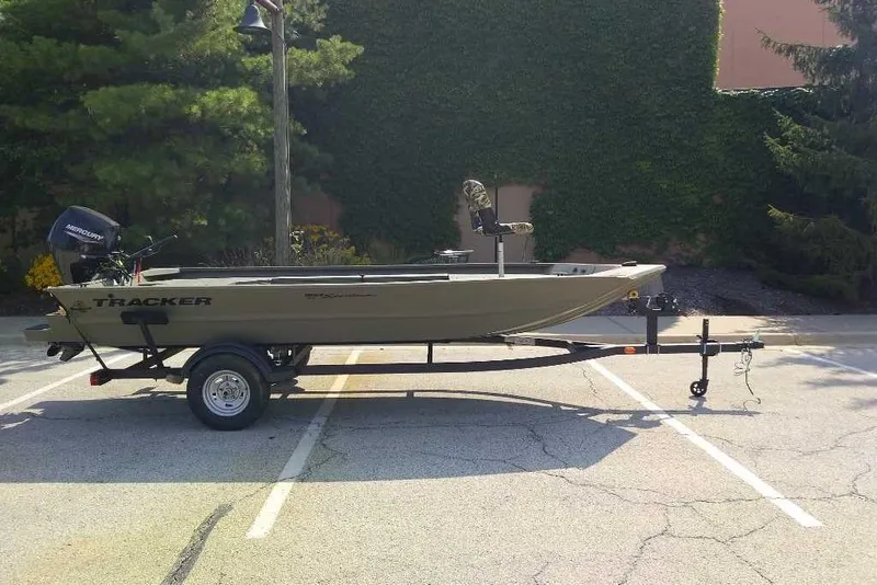 The Image of 2026 Tracker Grizzly 1654 T Sportsman boat on trailer in parking lot. - 0