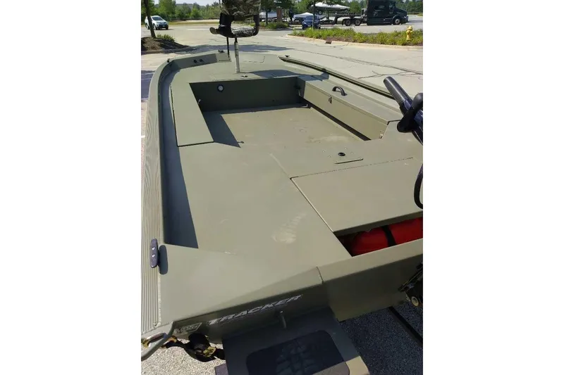 Slide: The Image of 2026 Tracker Grizzly 1654 T Sportsman boat, olive green, parked outdoors. - 2