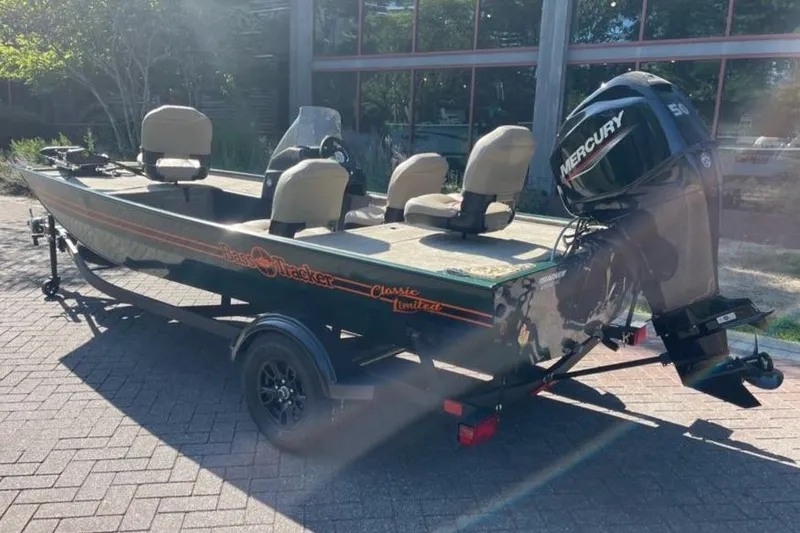 Slide: The Image of 2026 Tracker Bass Tracker Classic Limited boat with Mercury engine, parked outdoors. - 4