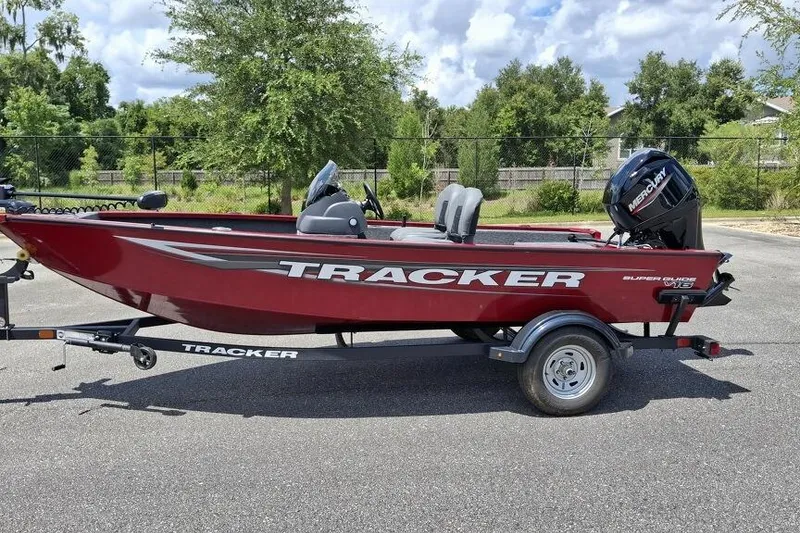 The Image of 2026 Tracker Super Guide V-16 SC boat on trailer, parked outdoors. - 0