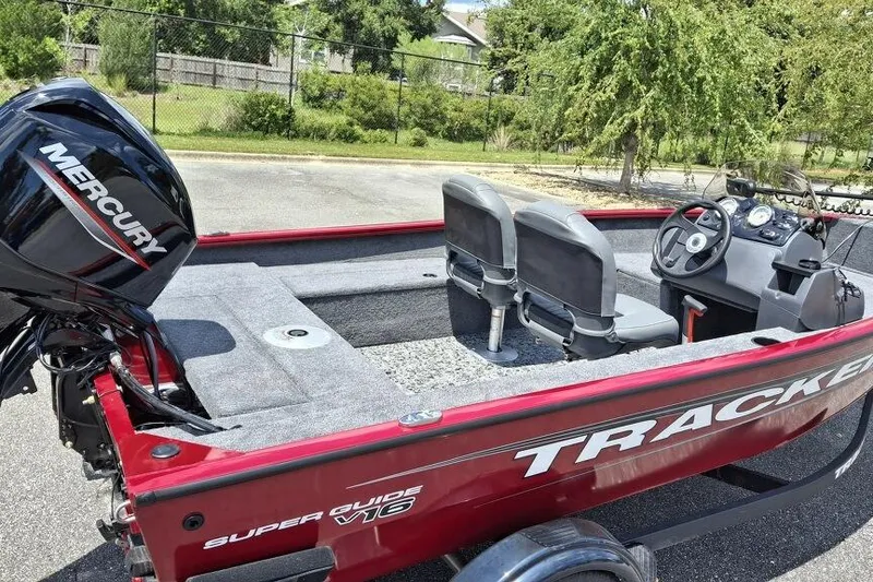 Slide: The Image of 2026 Tracker Super Guide V-16 SC boat with Mercury engine, parked outdoors. - 3