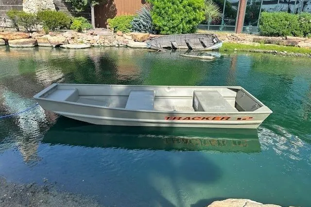 The Image of 2026 Tracker Grizzly 12 Jon boat floating on a serene pond. - 0