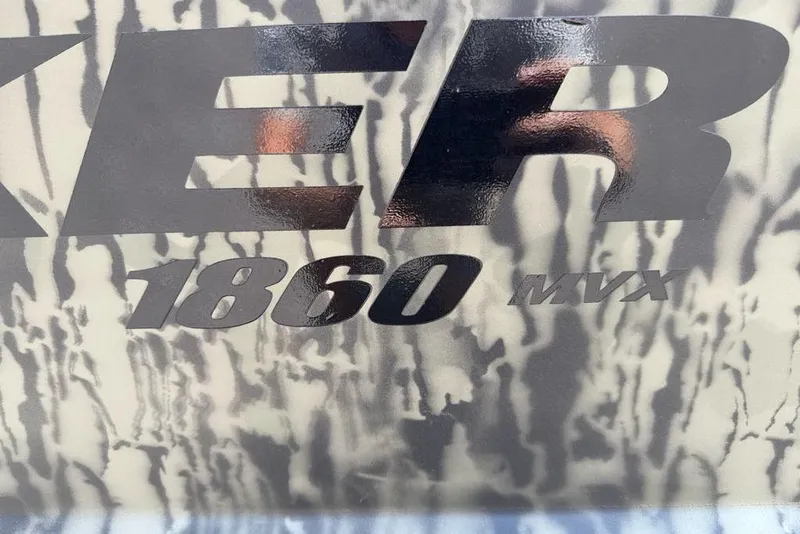 Slide: The Image of Tracker Grizzly 1860 MVX logo on camouflage background, 2026 model. - 2