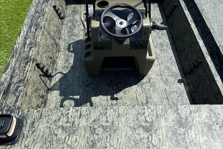 Slide: The Image of 2026 Tracker Grizzly 1860 CC boat interior with camouflage design and steering console. - 3