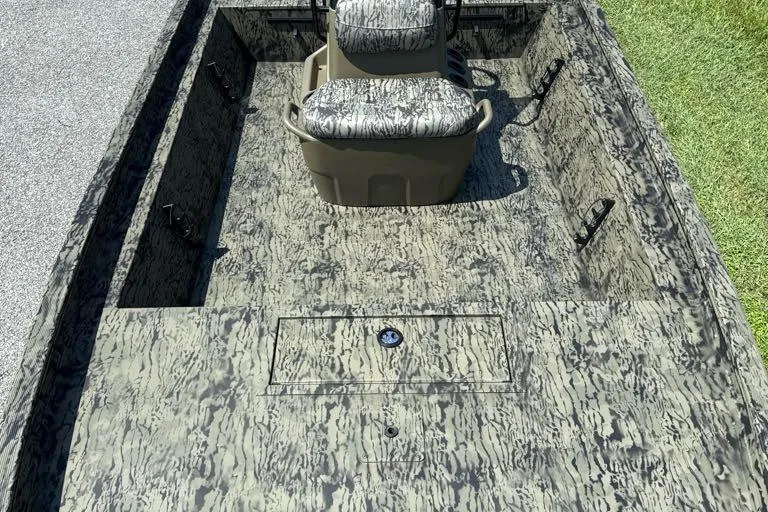 Slide: The Image of 2026 Tracker Grizzly 1860 CC boat interior with camouflage seating and storage compartments. - 4