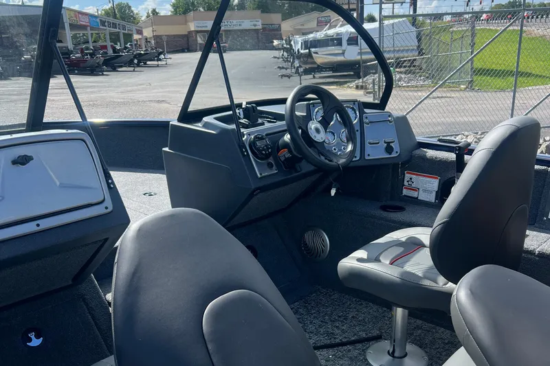 Slide: The Image of Interior of 2026 Tracker Pro Guide V-175 WT boat with steering wheel and seats. - 2
