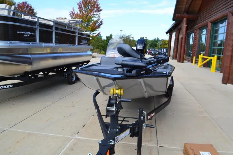 Slide: The Image of 2026 Tracker Bass Tracker Classic XL boat on trailer, parked outside a building. - 2