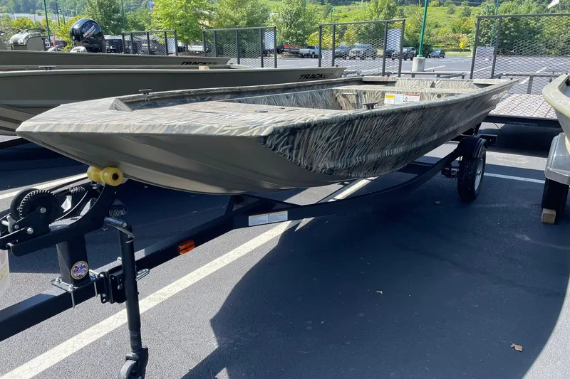 The Image of 2026 Tracker Grizzly 1648 Utility boat on trailer in parking lot. - 0