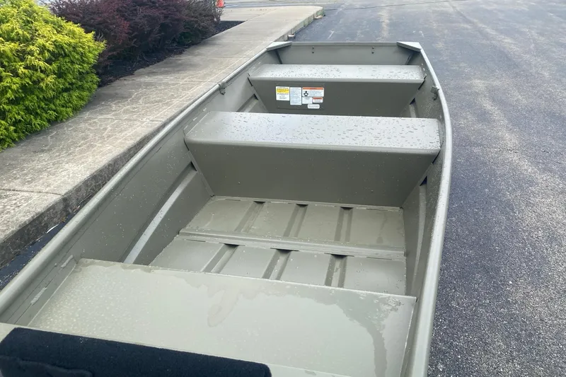 Slide: The Image of 2026 Tracker Grizzly 12 Jon boat on pavement, showcasing interior seating and design. - 3