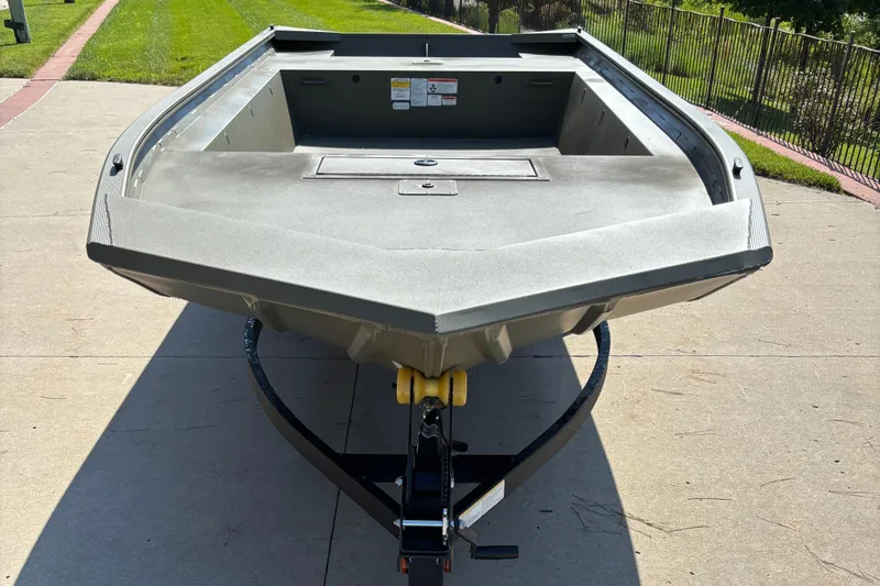 Slide: The Image of 2026 Tracker Grizzly 1754 Utility boat on trailer, parked on concrete driveway. - 2