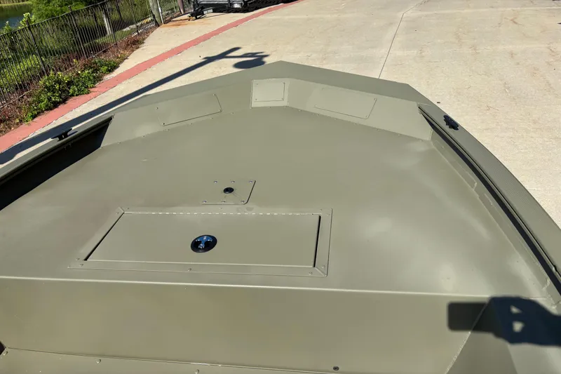 Slide: The Image of 2026 Tracker Grizzly 1754 Utility boat deck, olive green, parked on concrete. - 3