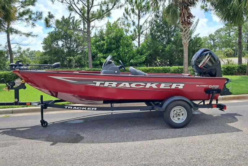 The Image of 2026 Tracker Super Guide V-16 SC boat on trailer, parked outdoors. - 0