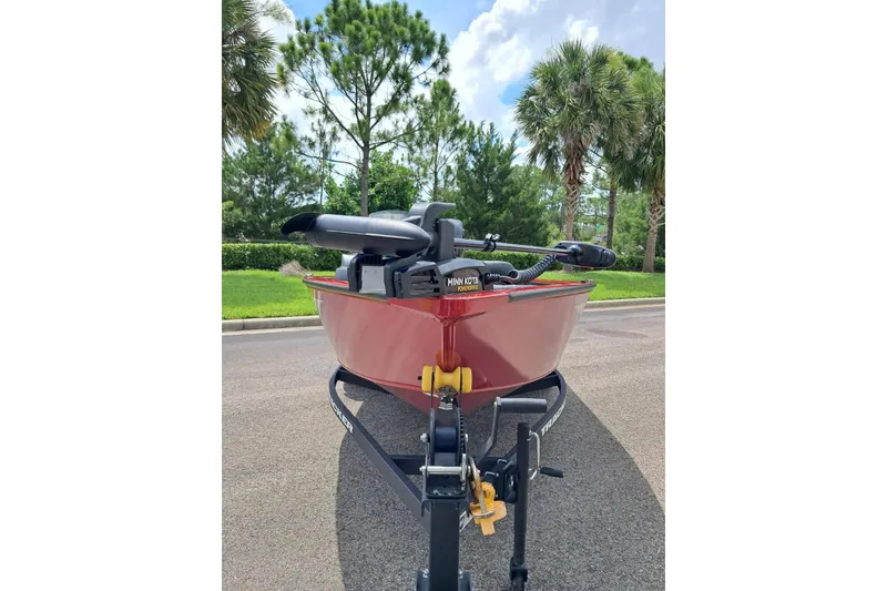 Slide: The Image of Red 2026 Tracker Super Guide V-16 SC boat on trailer, parked near palm trees. - 4