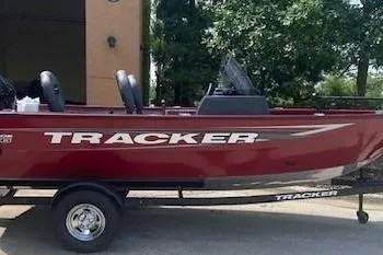 The Image of 2026 Tracker Super Guide V-16 SC boat, red exterior, parked on a trailer. - 0