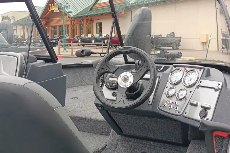 Slide: The Image of 2026 Tracker Pro Guide V-175 WT boat interior with steering wheel and dashboard gauges. - 2