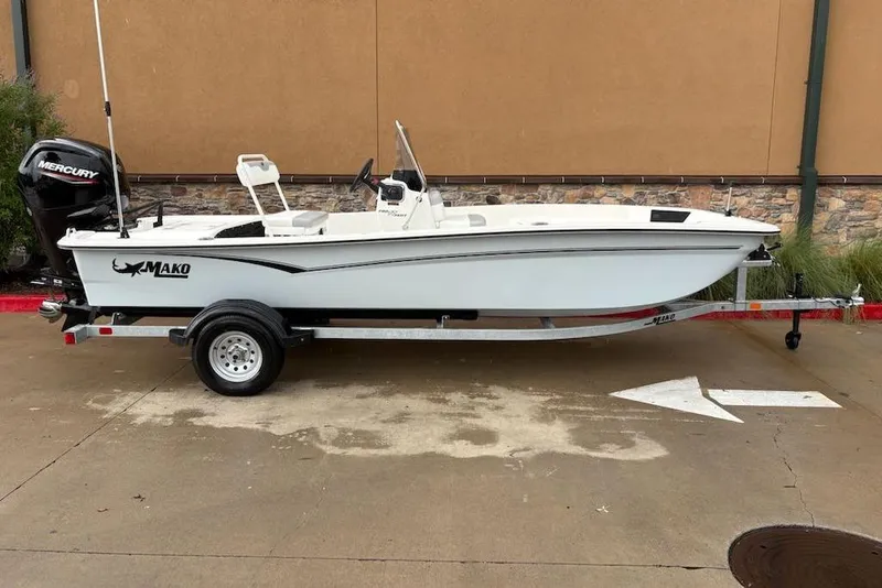 Slide: The Image of 2026 Mako Pro Skiff 17 CC boat on trailer, parked outdoors. - 2