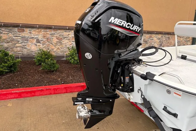 Slide: The Image of 2026 Mako Pro Skiff 17 CC with Mercury outboard motor, parked on concrete. - 7