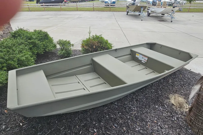 Slide: The Image of 2026 Tracker Grizzly 12 Jon boat displayed outdoors on a paved area. - 3