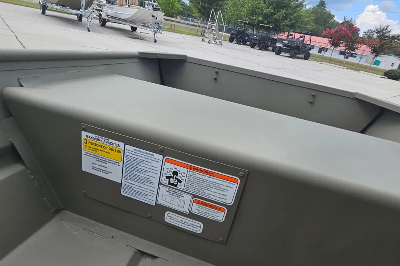 Slide: The Image of 2026 Tracker Grizzly 12 Jon boat interior with capacity and safety labels visible. - 4