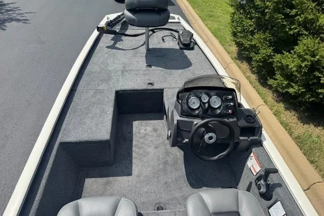 Slide: The Image of 2026 Tracker Pro 170 boat interior with steering console and seating, parked on a paved surface. - 3