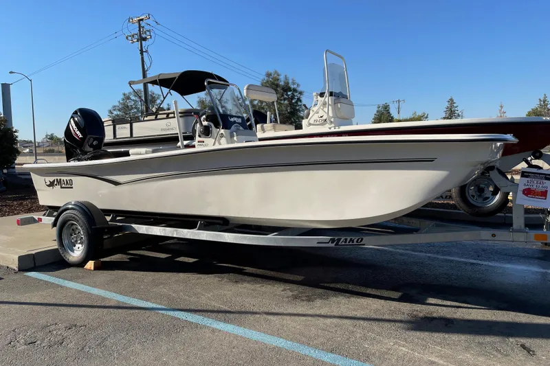 The Image of 2026 Mako Pro Skiff 17 CC boat on trailer, displayed outdoors under clear sky. - 0
