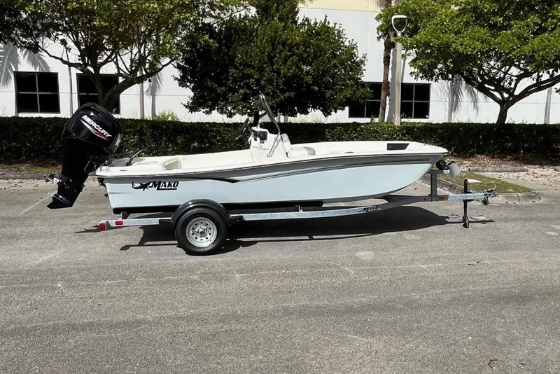 Slide: The Image of 2026 Mako Pro Skiff 15 CC boat on trailer, parked outdoors. - 1