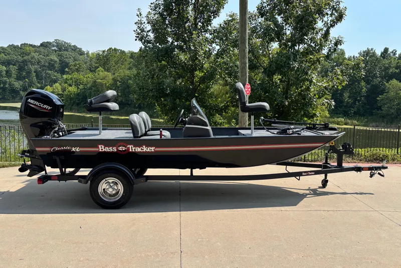 The Image of 2026 Tracker Bass Tracker Classic XL boat on trailer, parked near a scenic lake. - 0