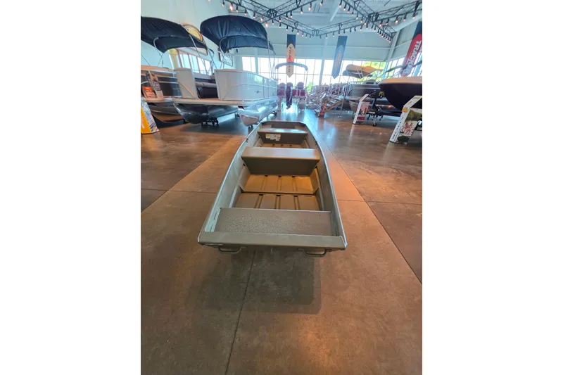 Slide: The Image of 2026 Tracker Grizzly 14 Jon boat displayed in a showroom with other boats. - 2