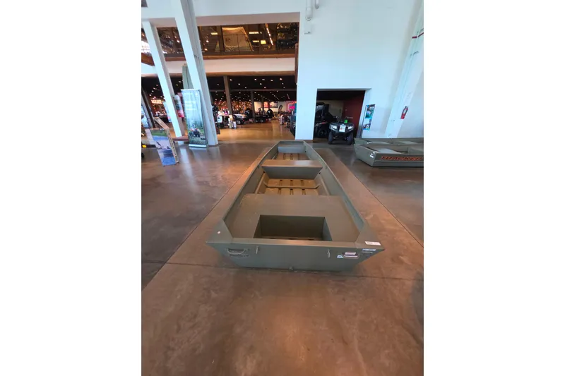 Slide: The Image of 2026 Tracker Grizzly 14 Jon boat displayed indoors on a polished concrete floor. - 62