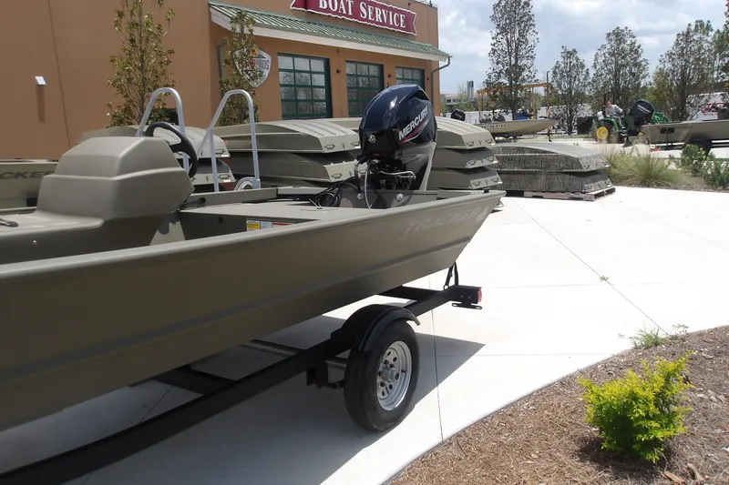 Slide: The Image of 2026 Tracker Grizzly 1648 SC boat displayed outdoors at a boat service center. - 3