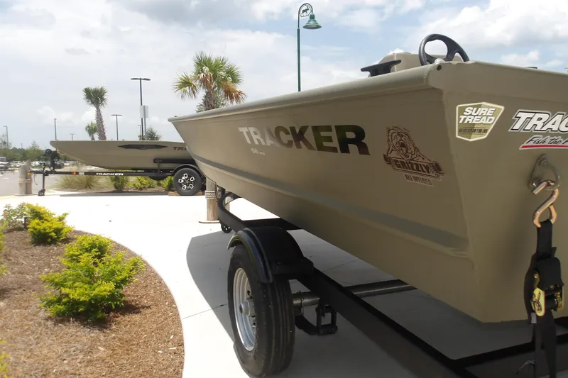 Slide: The Image of 2026 Tracker Grizzly 1648 SC boat on trailer, displayed outdoors with palm trees. - 8