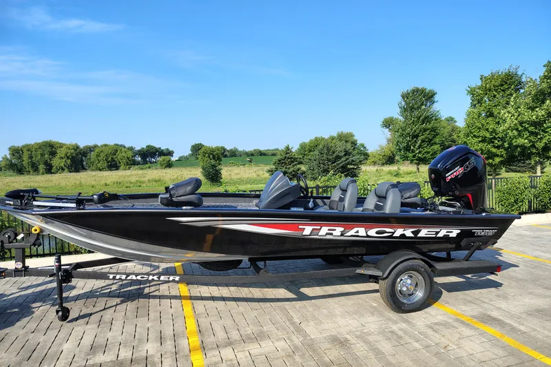 The Image of 2026 Tracker Pro Team 190 boat on trailer, parked outdoors with scenic background. - 0