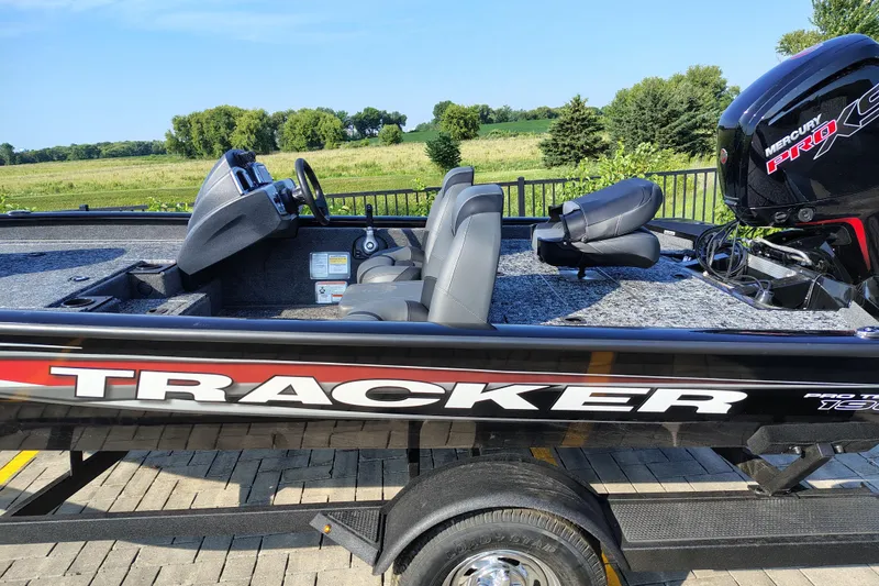 Slide: The Image of 2026 Tracker Pro Team 190 boat with Mercury engine, parked on a sunny day. - 2