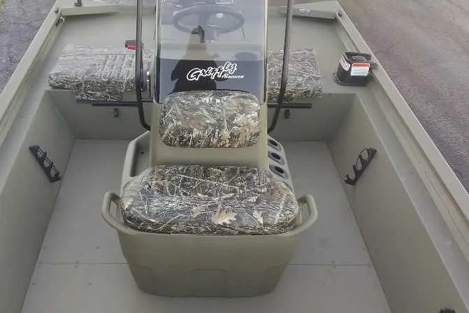 Slide: The Image of 2026 Tracker Grizzly 1860 CC boat interior with camouflage seating and steering console. - 3