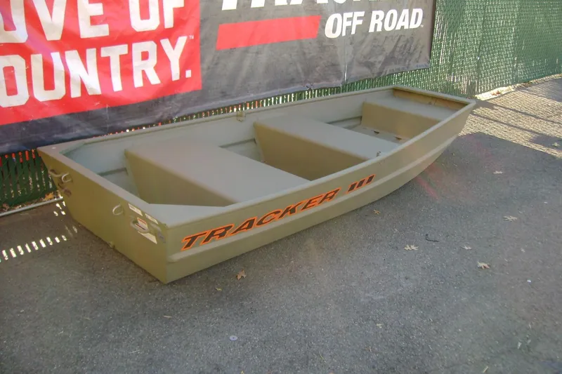 Slide: The Image of 2026 Tracker Grizzly 10 Jon boat displayed outdoors, featuring durable design and off-road branding. - 3