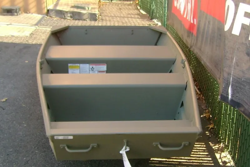 Slide: The Image of 2026 Tracker Grizzly 10 Jon boat, parked outdoors, showcasing interior seating and sturdy design. - 4