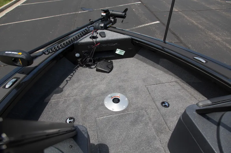 Slide: The Image of 2026 Tracker Targa V-18 WT boat interior with carpeted deck and trolling motor. - 2