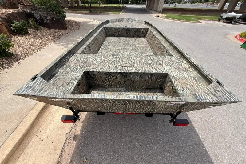 Slide: The Image of 2026 Tracker Grizzly 1860 Utility boat with camouflage design on a trailer. - 3