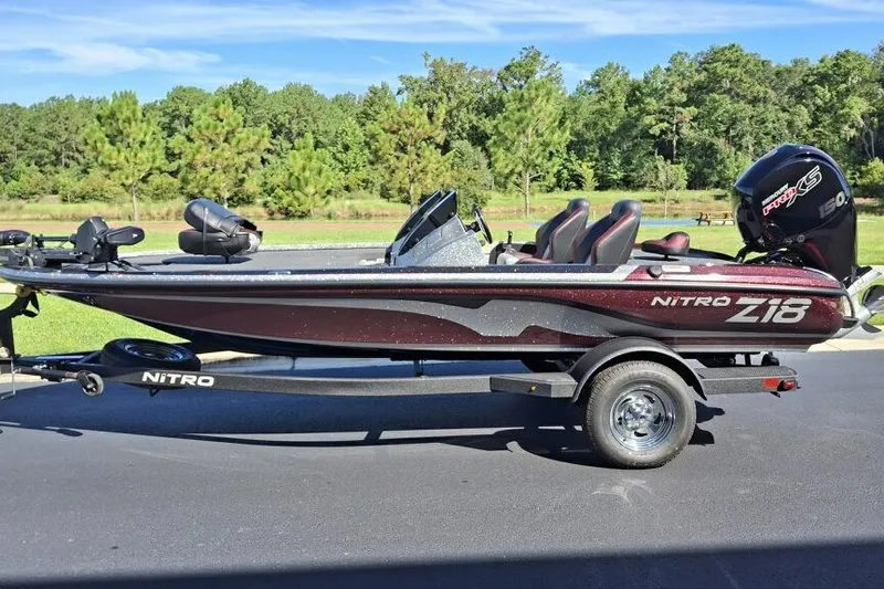 The Image of 2026 Nitro Z18 Pro bass boat on trailer, parked outdoors with trees in background. - 0