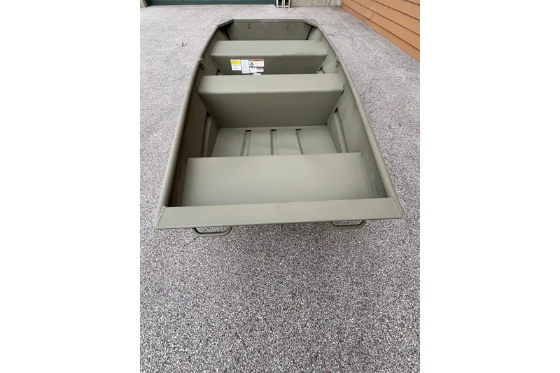 Slide: The Image of 2026 Tracker Grizzly 10 Jon boat on gravel surface, showcasing interior seating and design. - 2