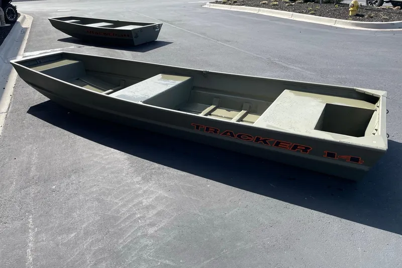 Slide: The Image of 2026 Tracker Grizzly 14 Jon boat on pavement, showcasing its sturdy design. - 2