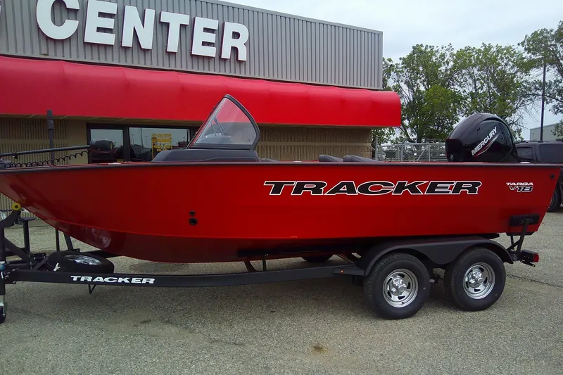 Slide: The Image of 2026 Tracker Targa V-18 Combo boat, red, on trailer outside a center. - 2