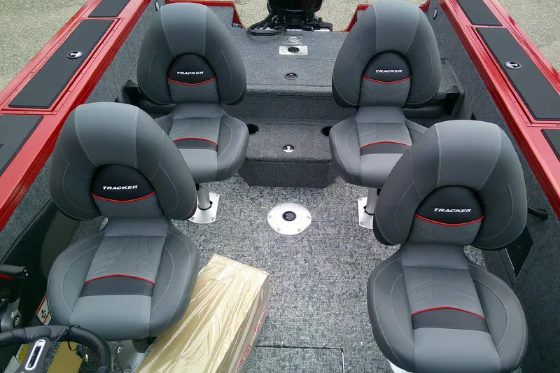 Slide: The Image of 2026 Tracker Targa V-18 Combo boat interior with four gray seats and red accents. - 7